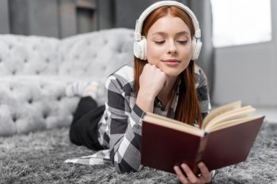 Chica leyendo libro y escuchando música